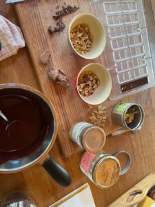 Moules pour mini tablettes de chocolat, ingrédients artisanaux et chocolat fondu au bain-marie.